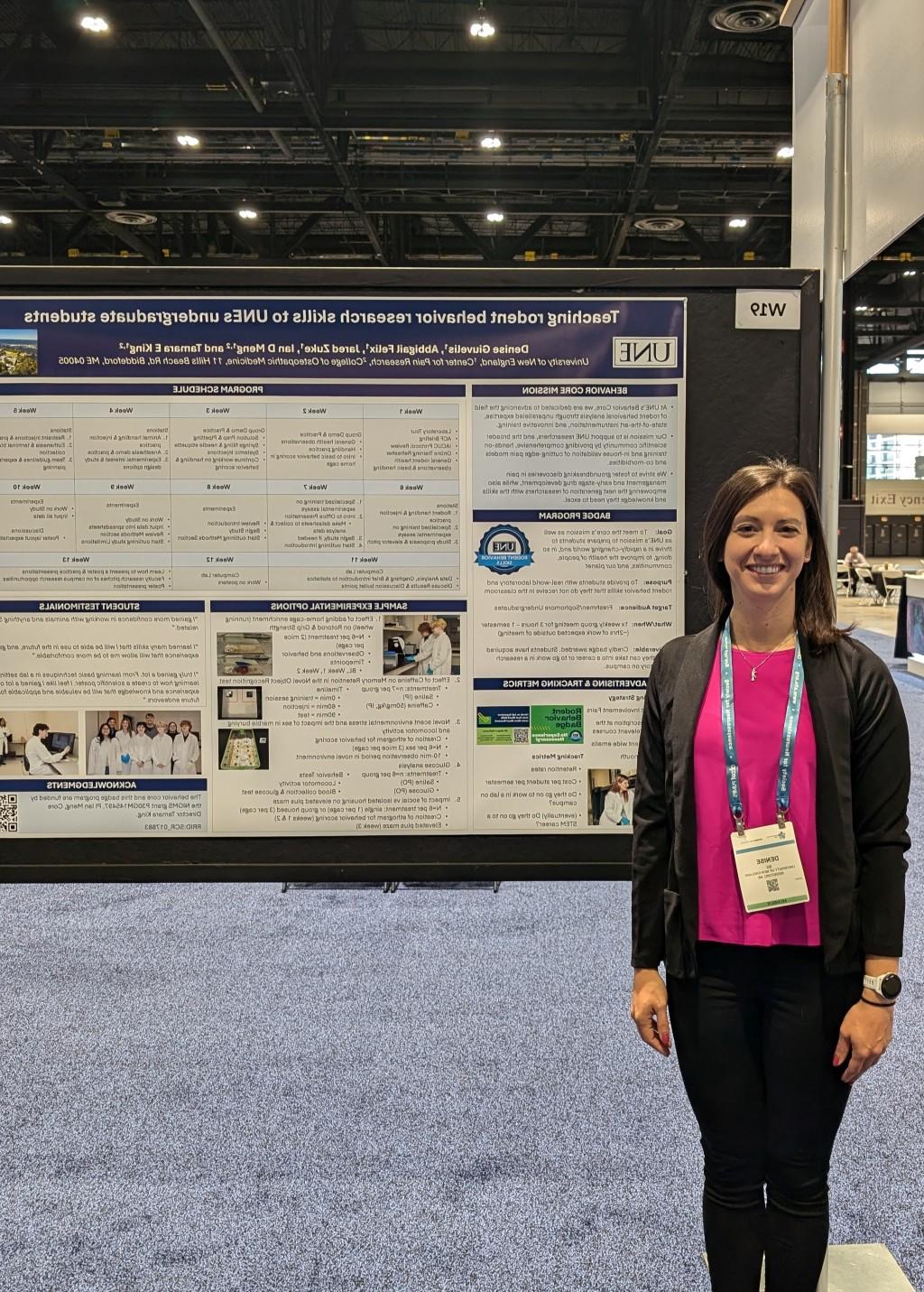 Denise Giuvelis, B.S., stands in front of her poster