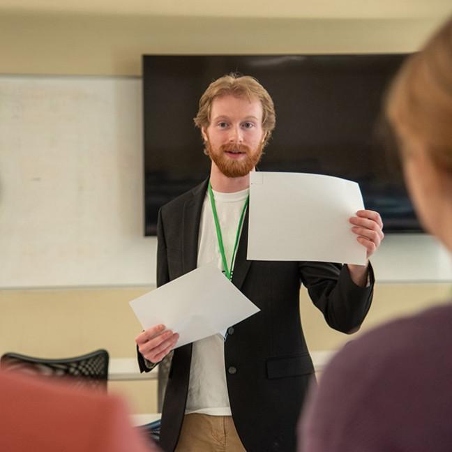 Student holding two pieces of paper